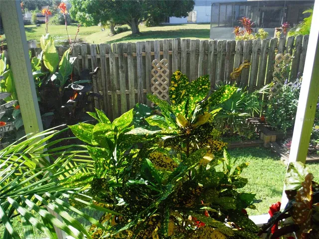 a garden with flowers and a wooden fence