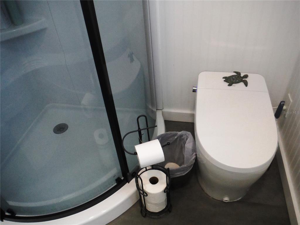 168 Pinewood Terrace, Unit 104 Safety Harbor, FL 34695 - Photo 30 of 55 a bathroom with a toilet and a mirror