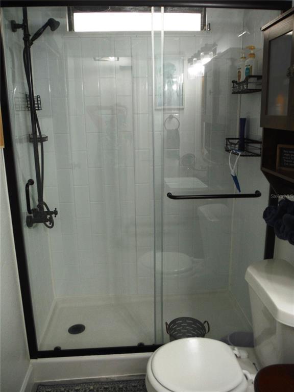 168 Pinewood Terrace, Unit 104 Safety Harbor, FL 34695 - Photo 31 of 55 a bathroom with a shower a toilet and a sink