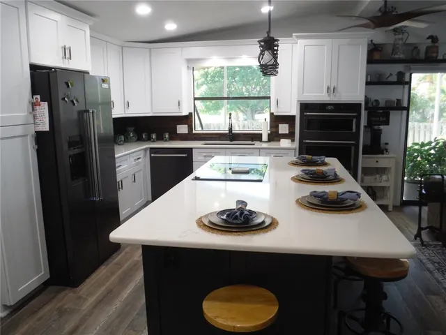 a kitchen with stainless steel appliances a stove a refrigerator and a stove
