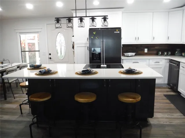 a kitchen with stainless steel appliances granite countertop a sink stove and white cabinets