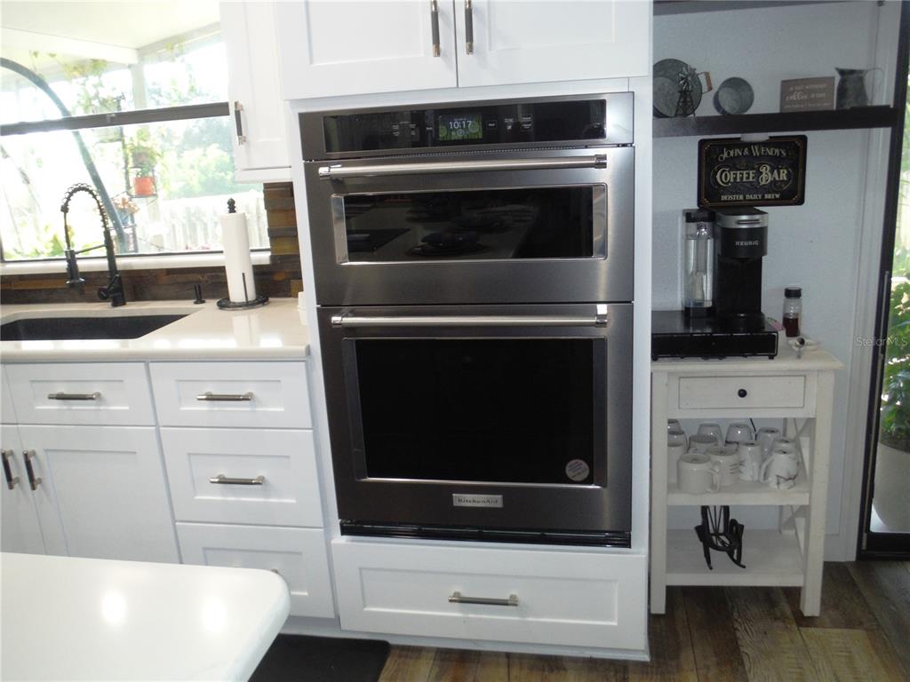 168 Pinewood Terrace, Unit 104 Safety Harbor, FL 34695 - Photo 7 of 55 a kitchen with a stove and a microwave
