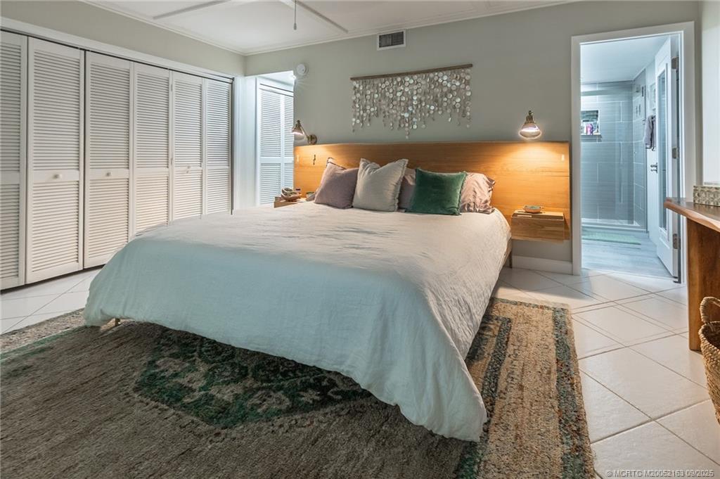 245 Northeast MacArthur Boulevard, Unit 18 Stuart, FL 34996 - Photo 11 of 15 a bedroom with a bed and wooden floor