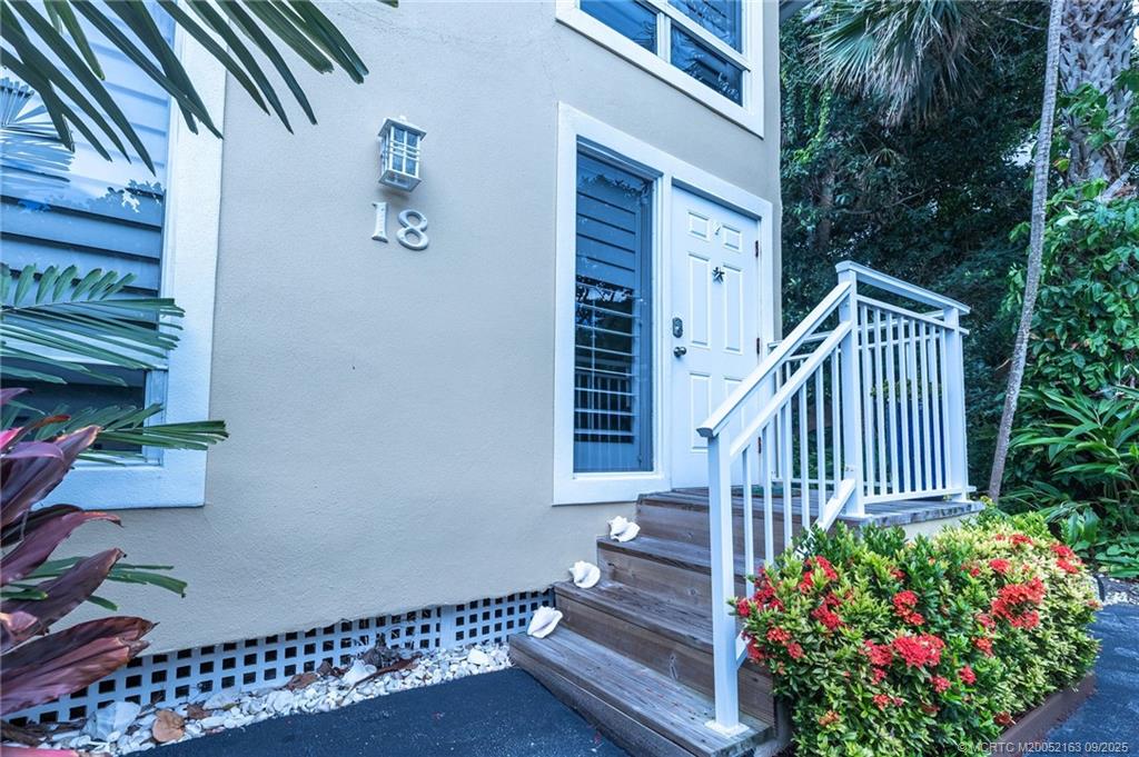 245 Northeast MacArthur Boulevard, Unit 18 Stuart, FL 34996 - Photo 15 of 15 a view of front door with potted plants