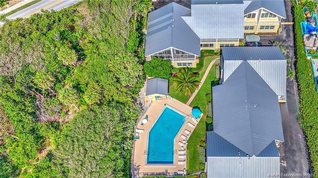245 Northeast MacArthur Boulevard, Unit 18 Stuart, FL 34996 - Photo 2 of 15 an aerial view of a house with a garden and trees