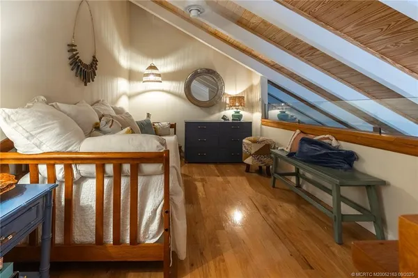 a bedroom with a bed and wooden floor