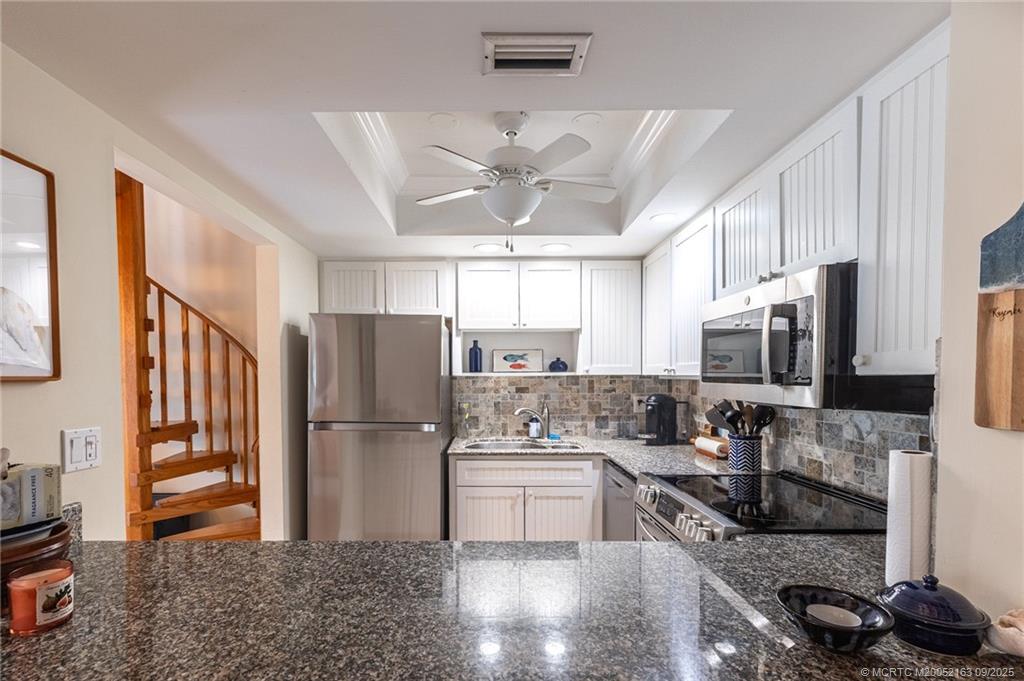 245 Northeast MacArthur Boulevard, Unit 18 Stuart, FL 34996 - Photo 10 of 15 a kitchen with stainless steel appliances granite countertop a refrigerator stove and sink
