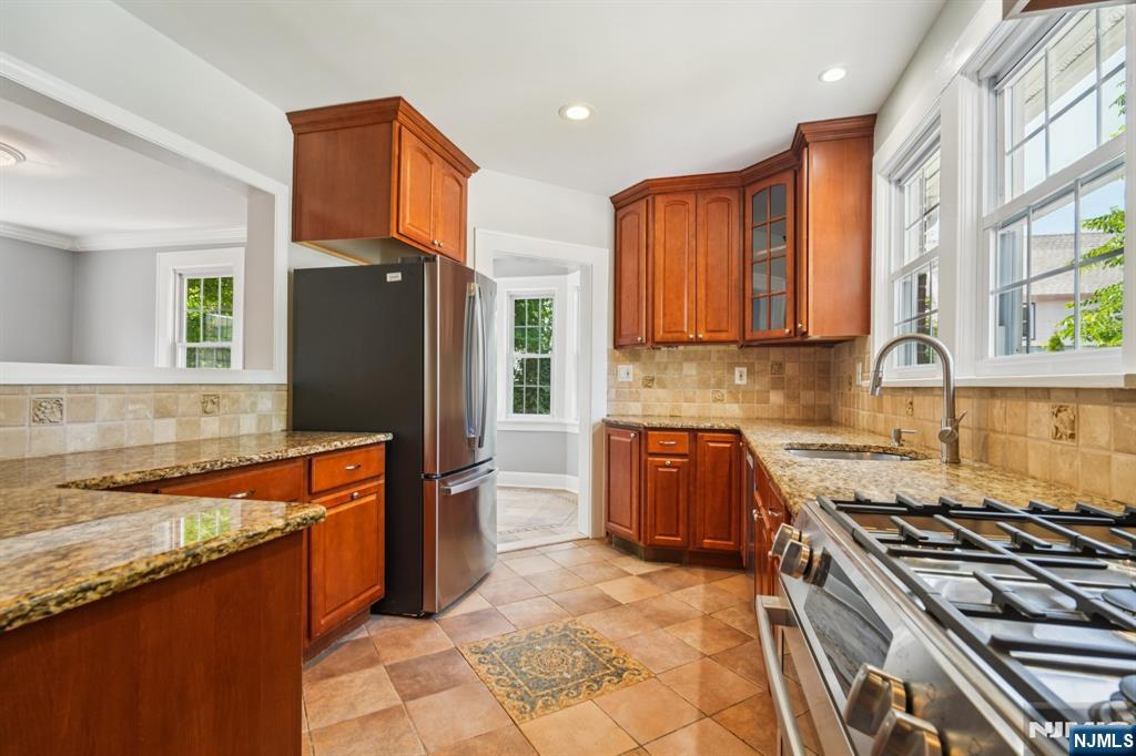 217 Grayson Place Teaneck, NJ 07666 - Photo 14 of 40 a kitchen with stainless steel appliances granite countertop a stove a sink and a refrigerator