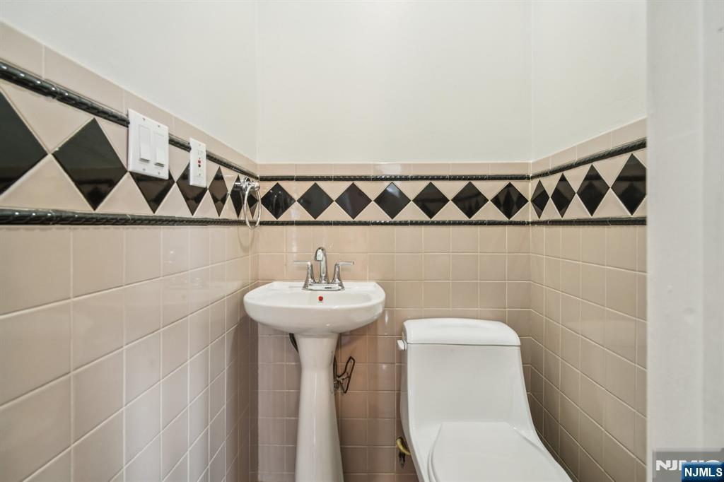 217 Grayson Place Teaneck, NJ 07666 - Photo 17 of 40 a bathroom with a sink a toilet and a mirror