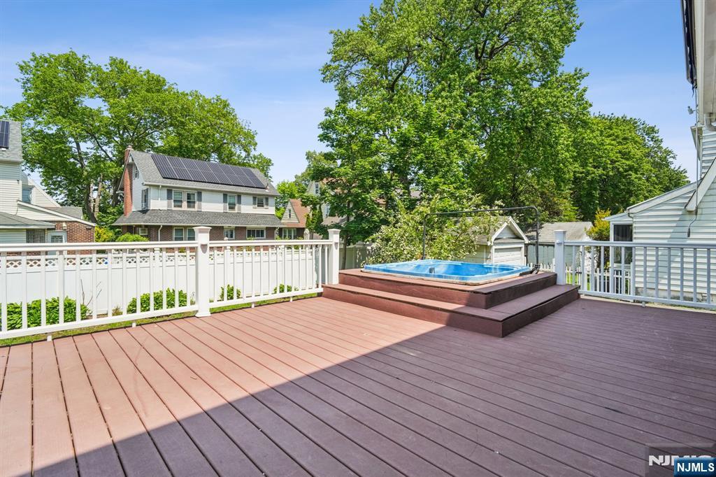 217 Grayson Place Teaneck, NJ 07666 - Photo 27 of 40 a view of house with deck outdoor seating and trees in the background