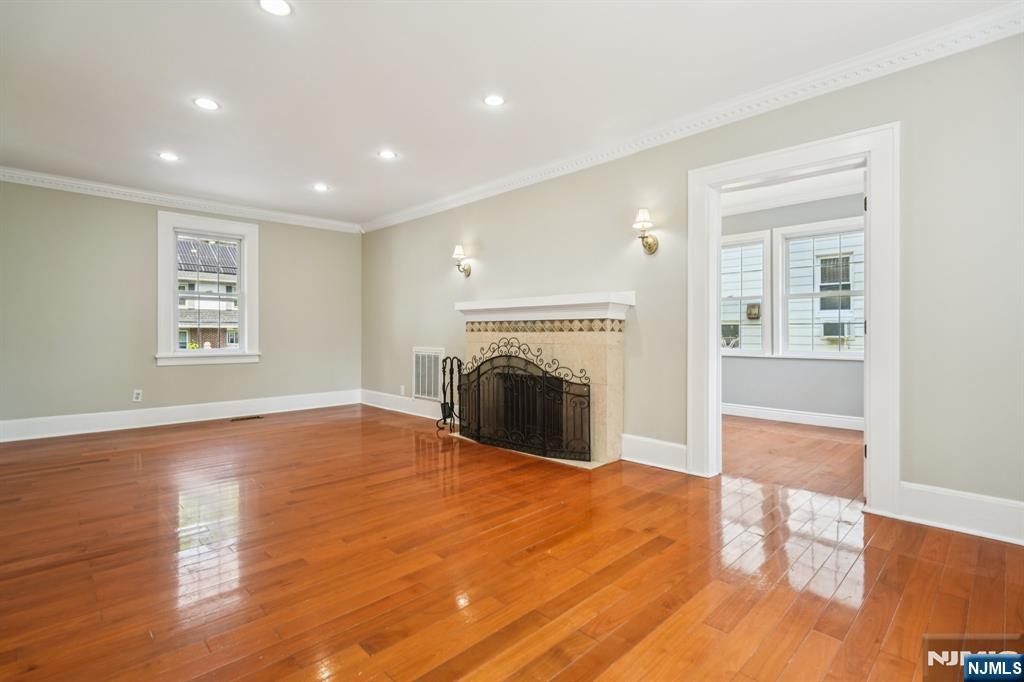 217 Grayson Place Teaneck, NJ 07666 - Photo 5 of 40 a view of empty room with wooden floor and fireplace