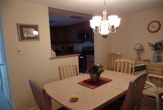 a view of a dining room with furniture a chandelier and wooden floor