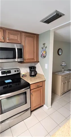 a kitchen with cabinets stainless steel appliances and a sink