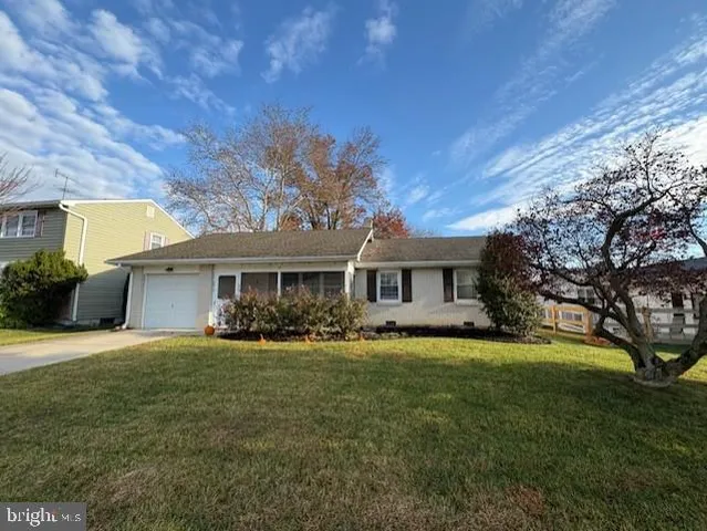 a front view of a house with a yard and trees