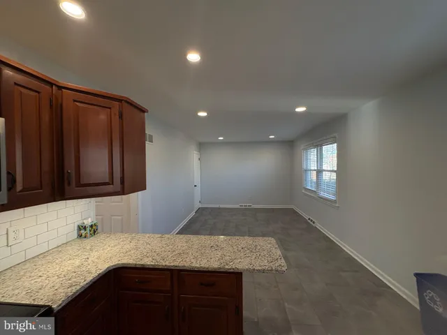 a kitchen with a granite countertop sink and cabinets