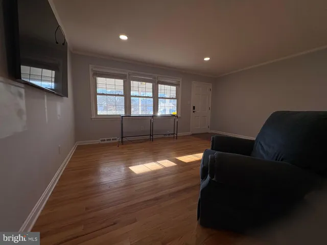 a living room with furniture and a hard wood floor