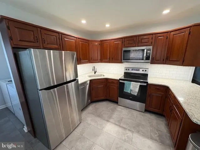 a kitchen with stainless steel appliances granite countertop a refrigerator stove microwave and sink