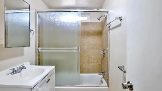 a bathroom with a shower sink vanity and mirror