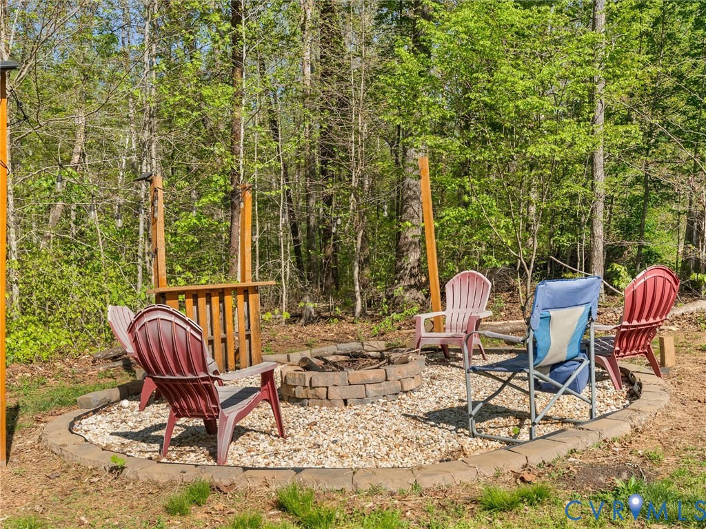 126 Reedy Creek Road Louisa, VA 23093 - Photo 62 of 65 Outdoor fire pit area with a gravel base and a sto