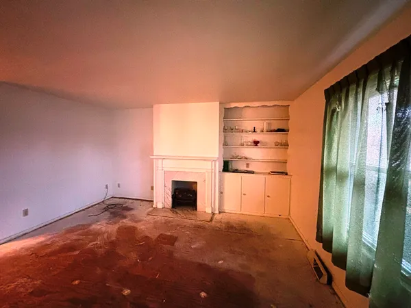 a view of empty room with a fireplace and entryway