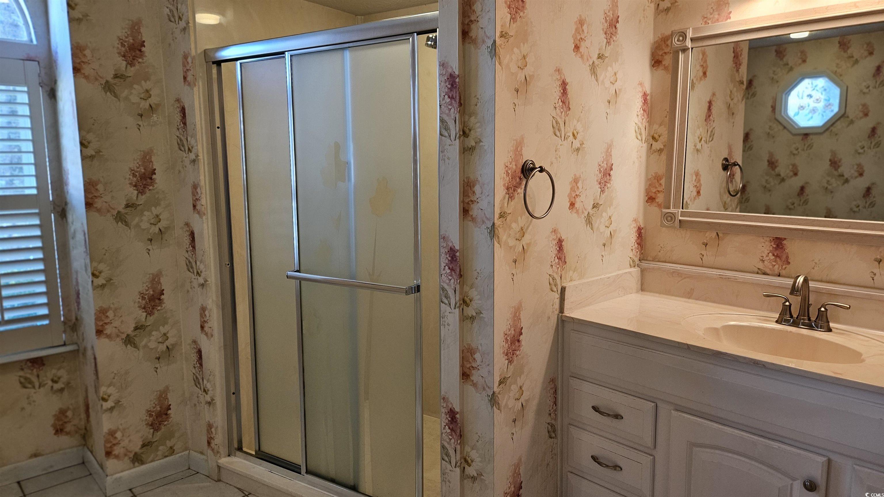 545 Saluda River Road Myrtle Beach, SC 29588 - Photo 20 of 25 Bathroom featuring wallpapered walls, vanity, a shower stall, and tile patterned flooring