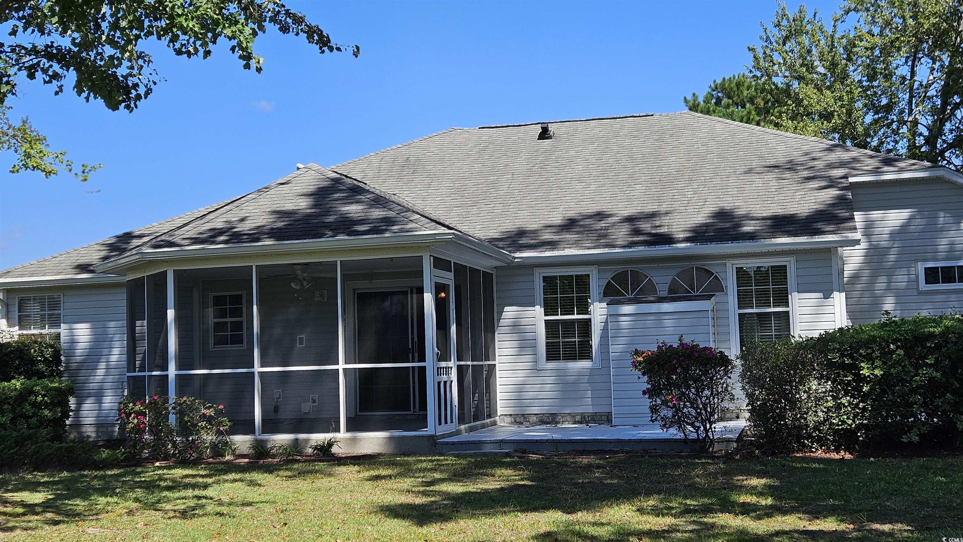 545 Saluda River Road Myrtle Beach, SC 29588 - Photo 25 of 25 Rear view of house featuring a sunroom, a lawn, and roof with shingles