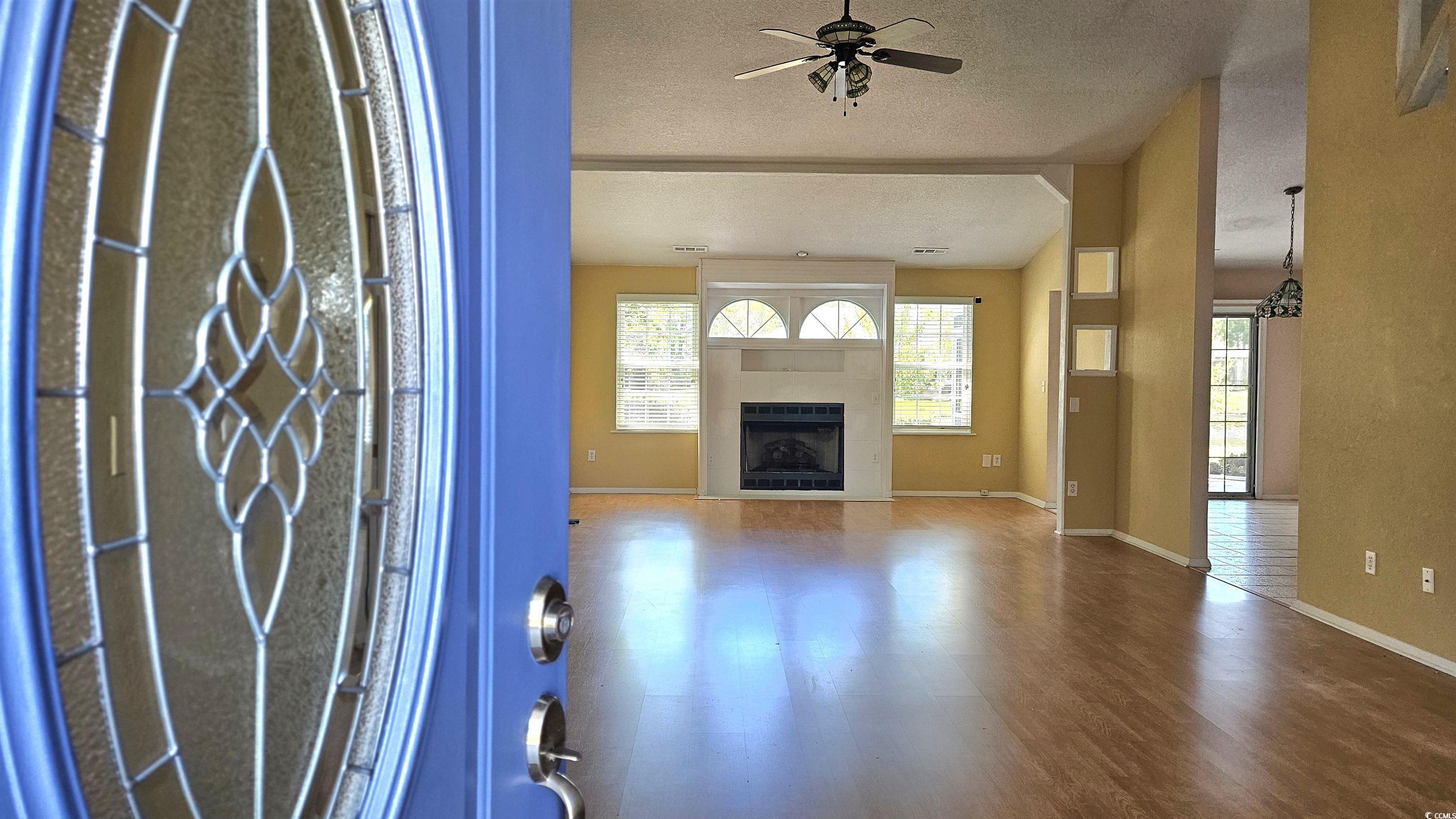 545 Saluda River Road Myrtle Beach, SC 29588 - Photo 4 of 25 Wood finished floors, a fireplace, and a ceiling fan