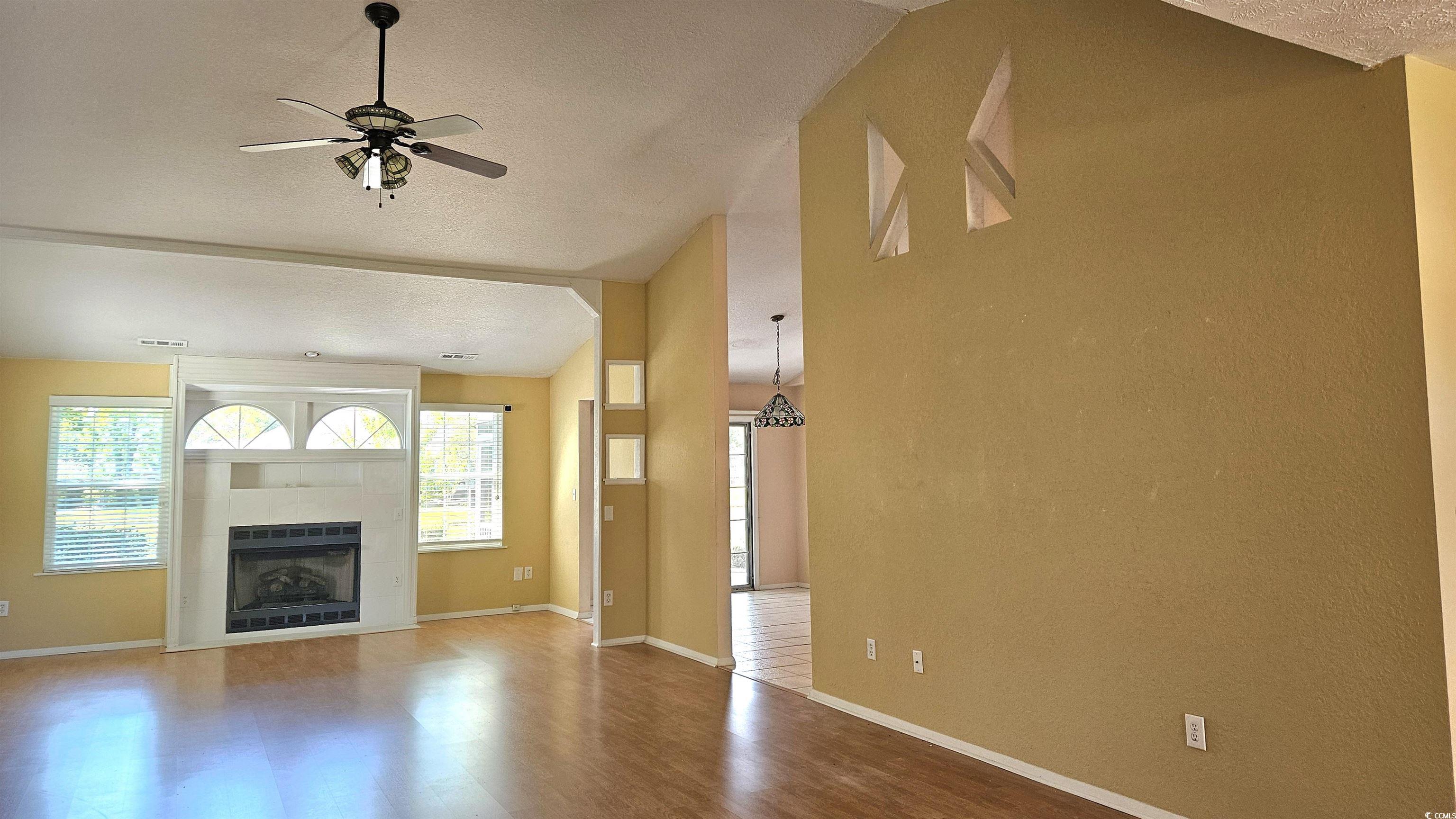 545 Saluda River Road Myrtle Beach, SC 29588 - Photo 5 of 25 Wood finished floors, lofted ceiling, a tiled fireplace, and a ceiling fan