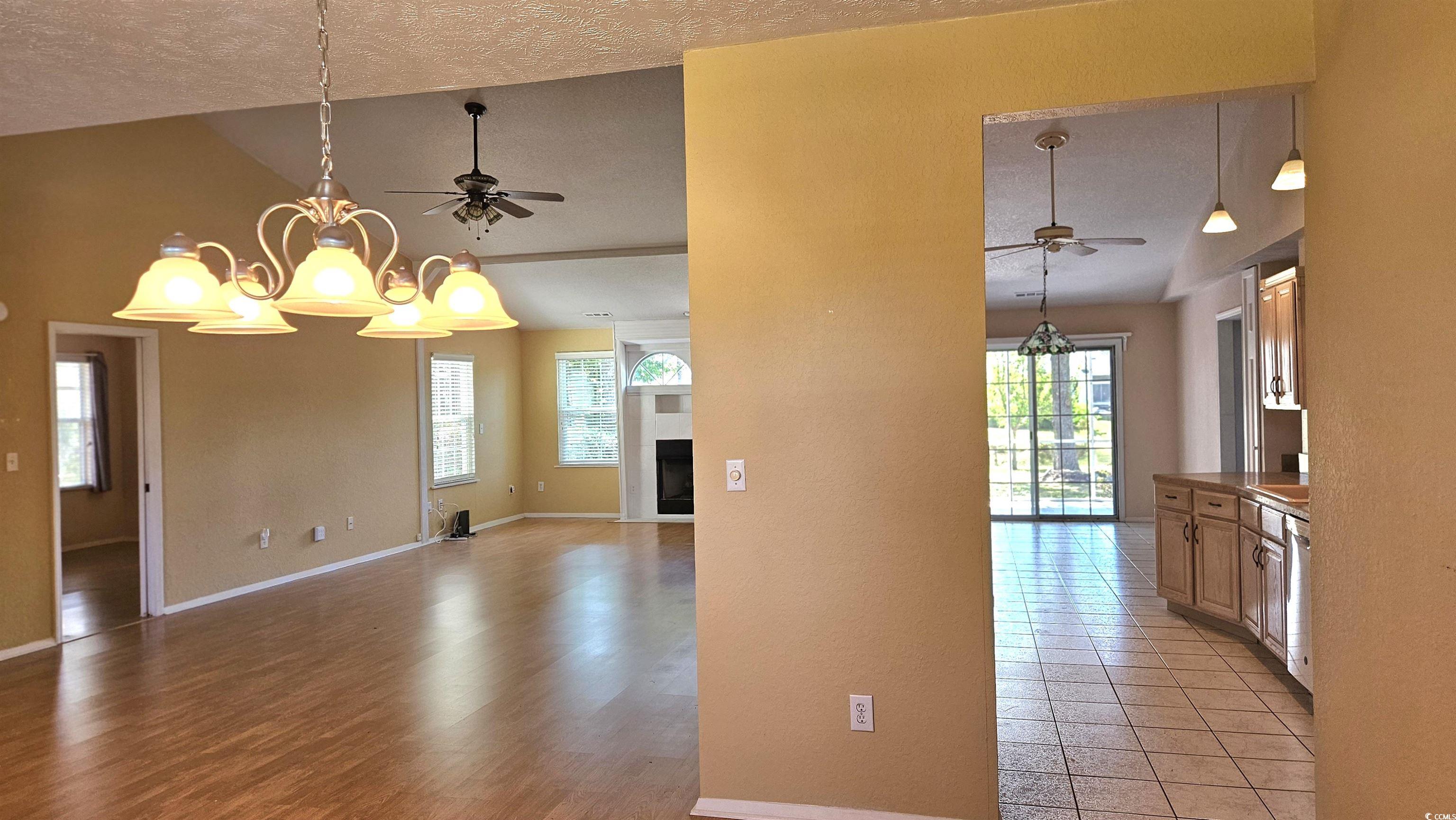 545 Saluda River Road Myrtle Beach, SC 29588 - Photo 8 of 25 Unfurnished room with ceiling fan, plenty of natural light, a chandelier, lofted ceiling, and a textured ceiling