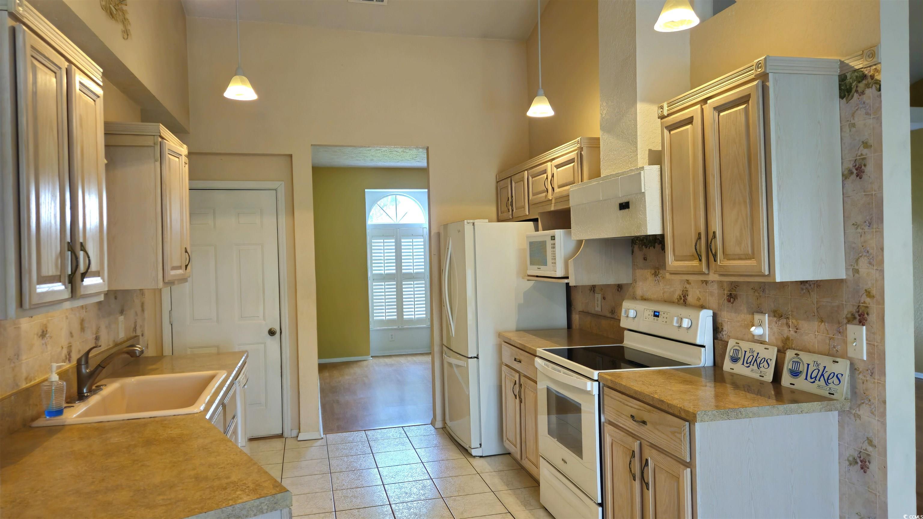 545 Saluda River Road Myrtle Beach, SC 29588 - Photo 9 of 25 Kitchen with white appliances, light tile patterned floors, and pendant lighting