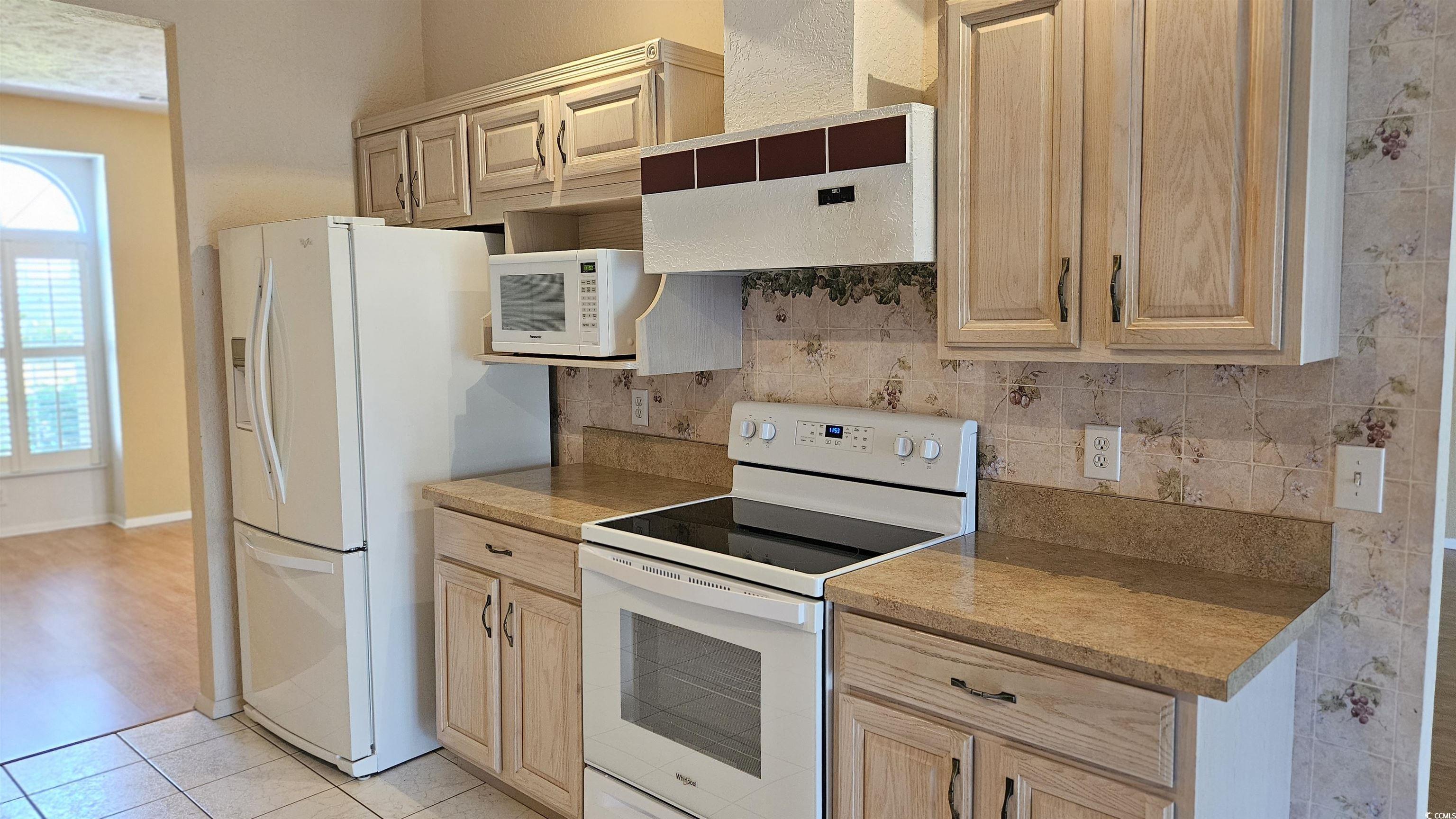 545 Saluda River Road Myrtle Beach, SC 29588 - Photo 10 of 25 Kitchen with white appliances, light brown cabinets, and ventilation hood