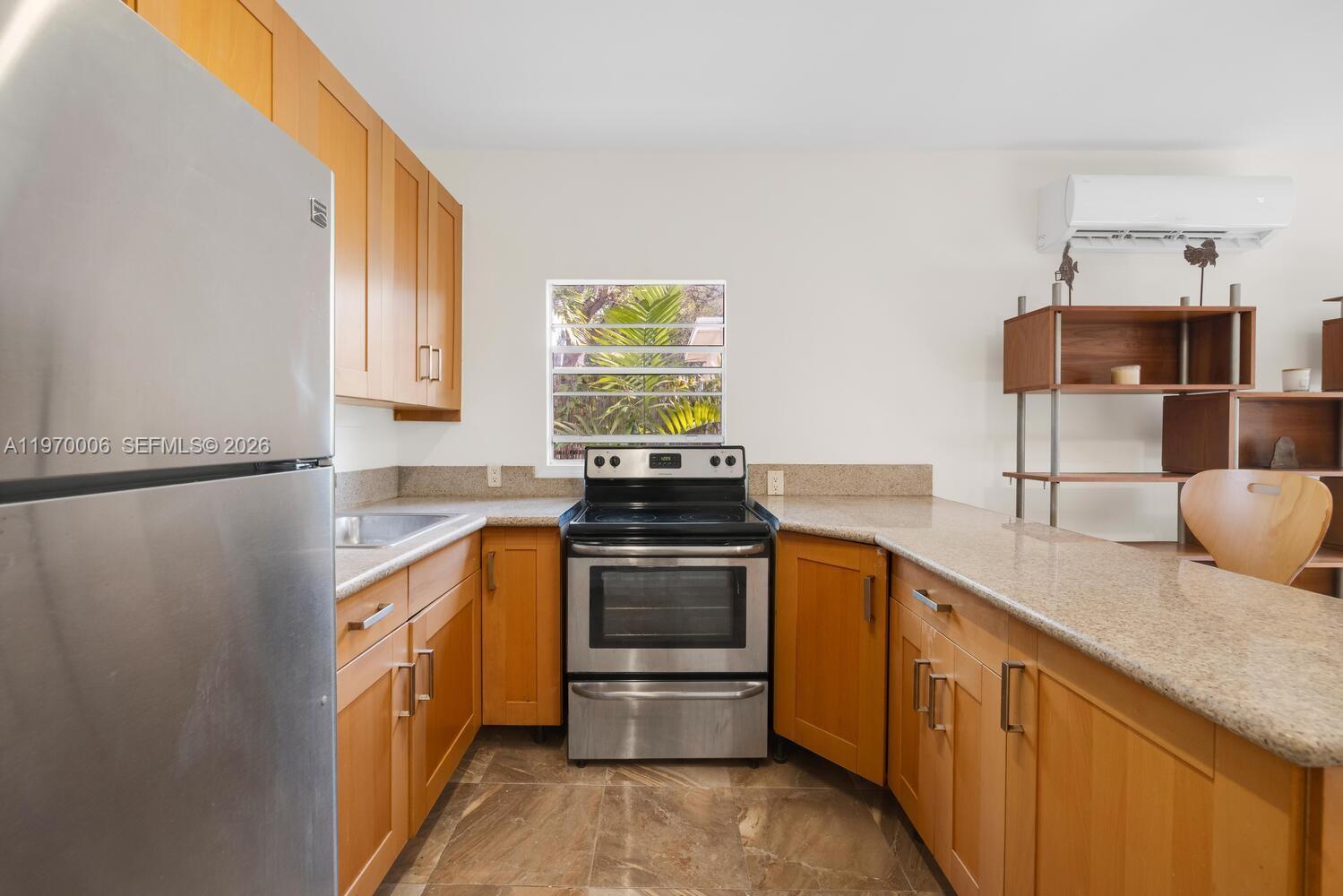 645 Northeast 62nd Street Miami, FL 33138 - Photo 26 of 32 a kitchen with stainless steel appliances granite countertop a stove a sink and a refrigerator