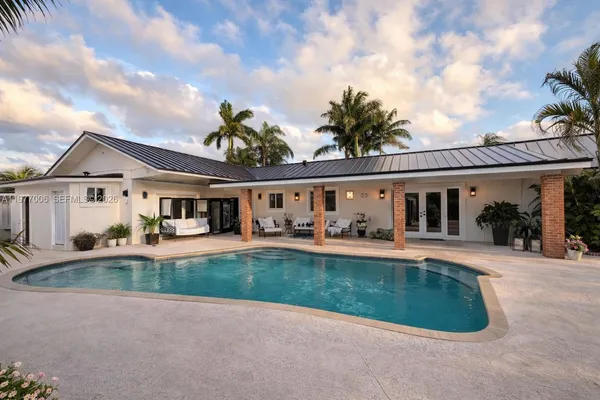 front view of a house with swimming pool having outdoor seating