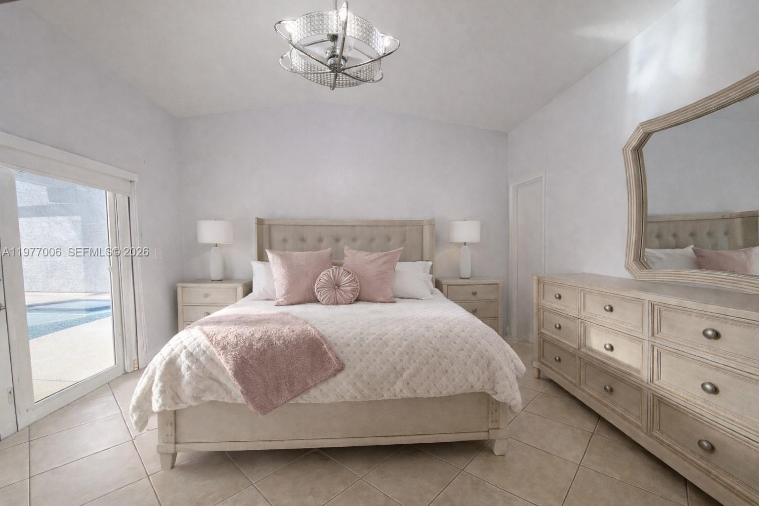 12901 Southwest 191st Street Miami, FL 33177 - Photo 13 of 27 a bedroom with a bed and window with lamp