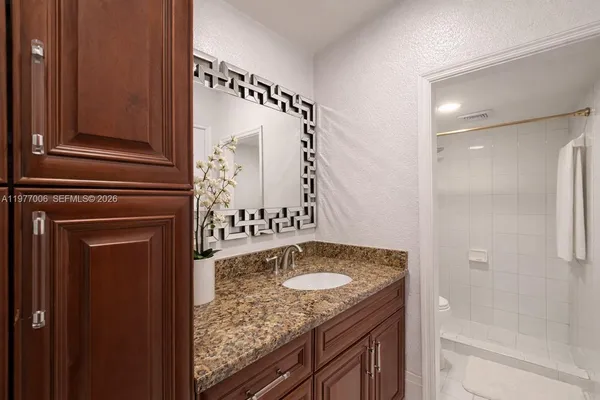 a bathroom with a granite countertop sink and a mirror