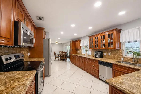 a kitchen with stainless steel appliances granite countertop a stove a sink and a microwave