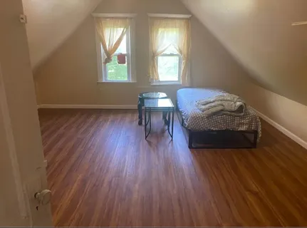 a bedroom with a bed and a wooden floor