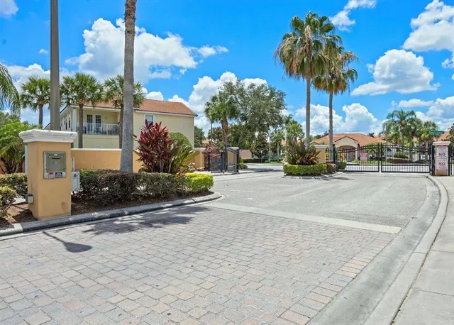 a view of a street with a building and palm trees