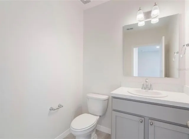a bathroom with a toilet a sink and mirror