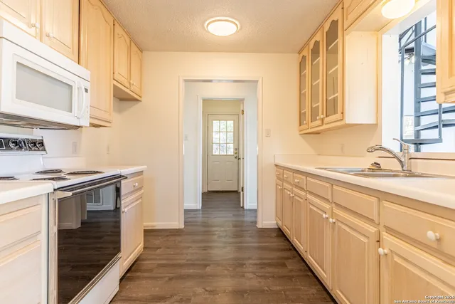 a kitchen with granite countertop a sink and a stove top oven