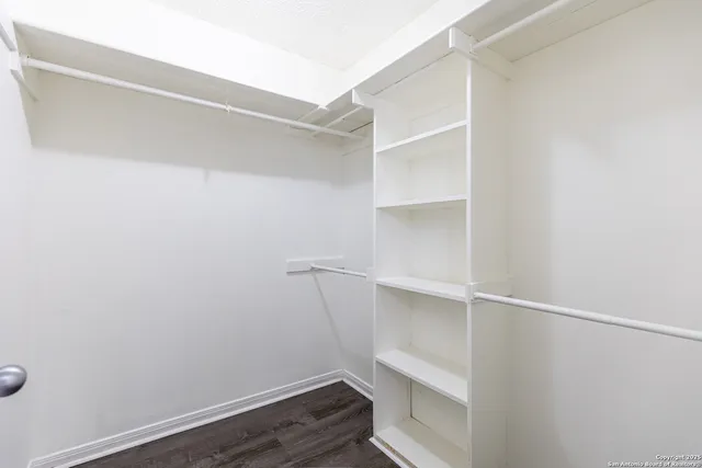 a view of walk in closet with empty racks