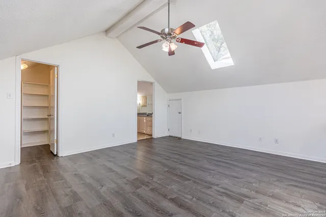 an empty room with a ceiling fan and wooden floor