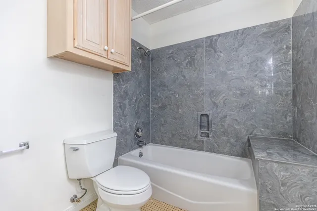 a white bath tub sitting next to a toilet