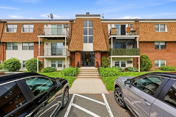 a front view of a residential apartment building with a yard