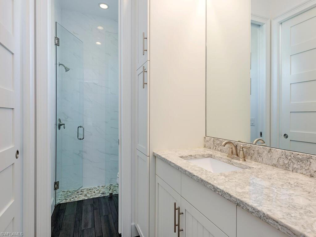 6399 Warwick Avenue Naples, FL 34113 - Photo 12 of 30 a bathroom with a granite countertop sink and a mirror
