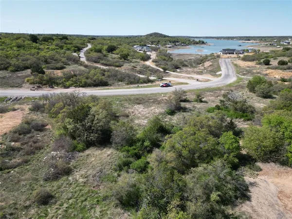 an aerial view of residential houses with outdoor space and trees
