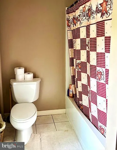 a bathroom with a granite countertop sink a toilet and a mirror