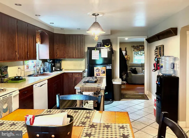 a kitchen with a stove a sink dishwasher and a dining table with kitchen view