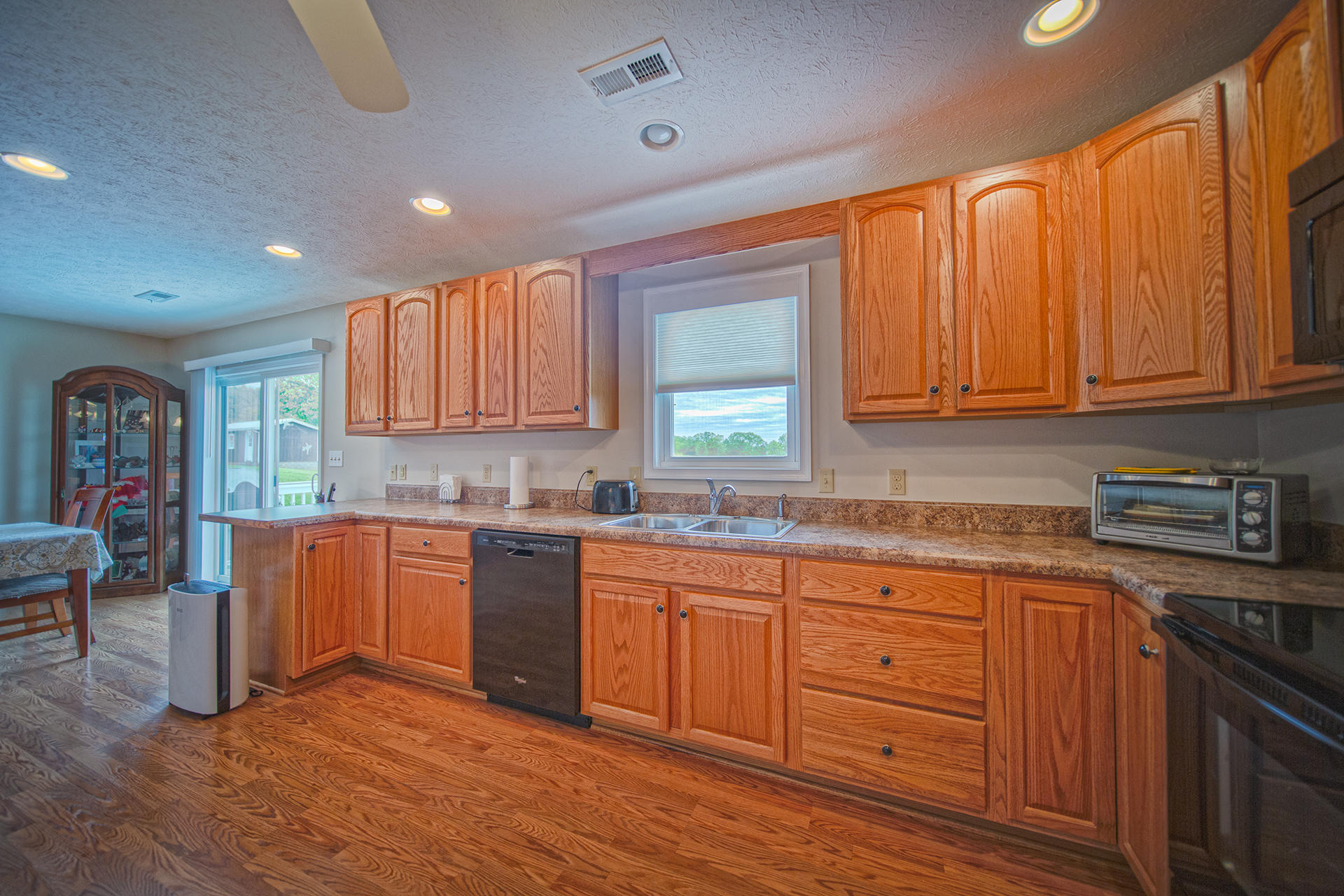 3746 Horseshoe Bend Road Goodview, VA 24095 - Photo 13 of 35 a kitchen with granite countertop wooden cabinets stainless steel appliances a sink and a window