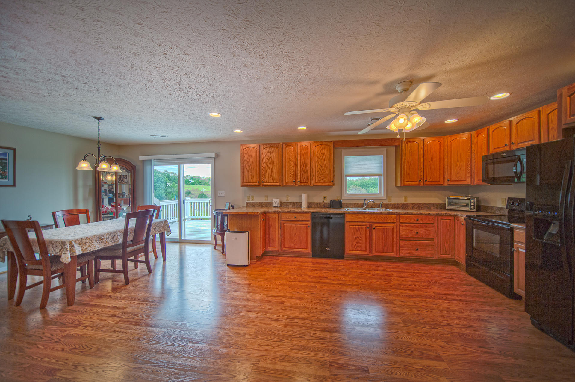 3746 Horseshoe Bend Road Goodview, VA 24095 - Photo 14 of 35 a kitchen with stainless steel appliances wooden floor dining table and chairs